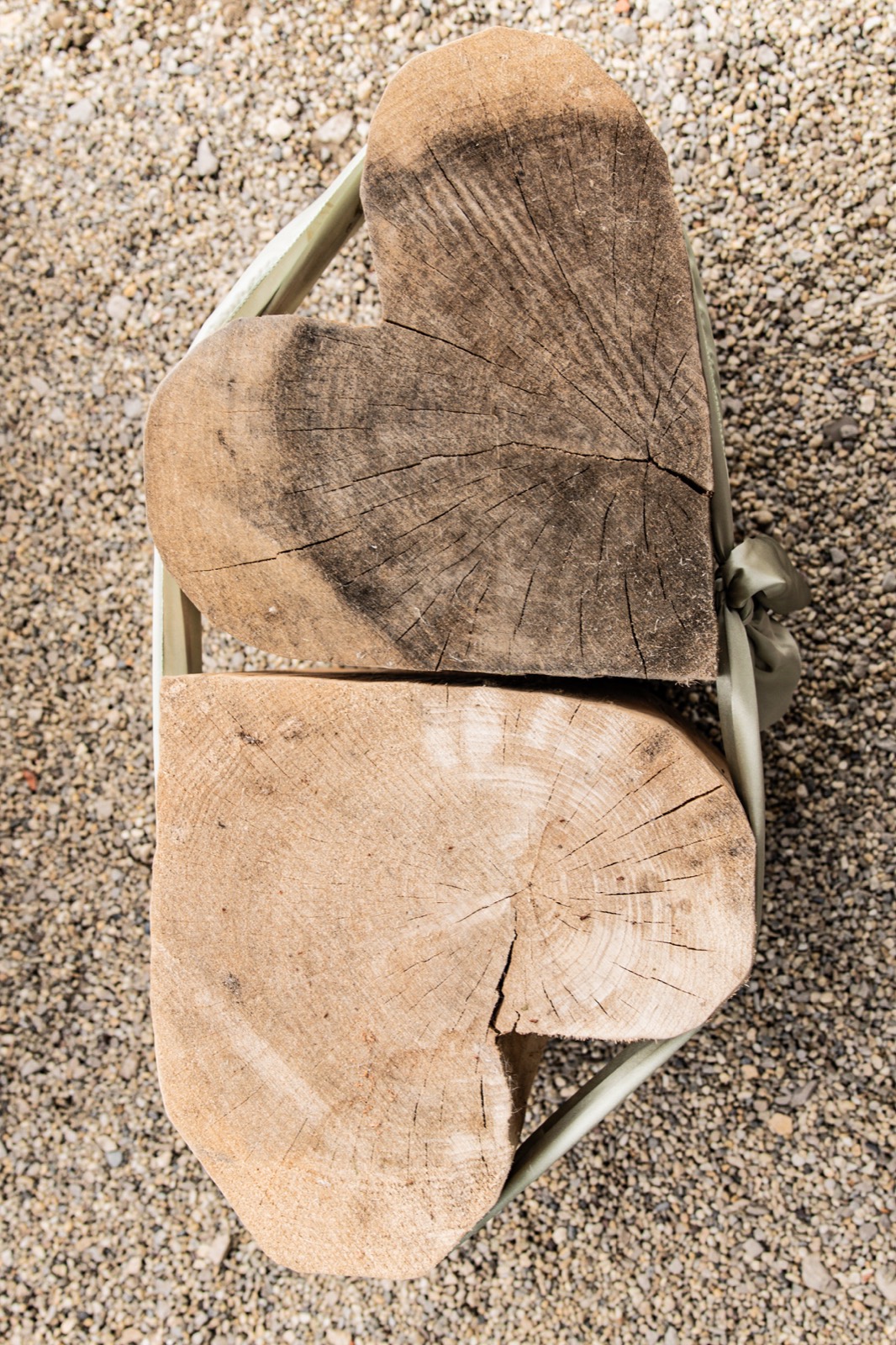 Herzförmige Holzscheiben im Sand