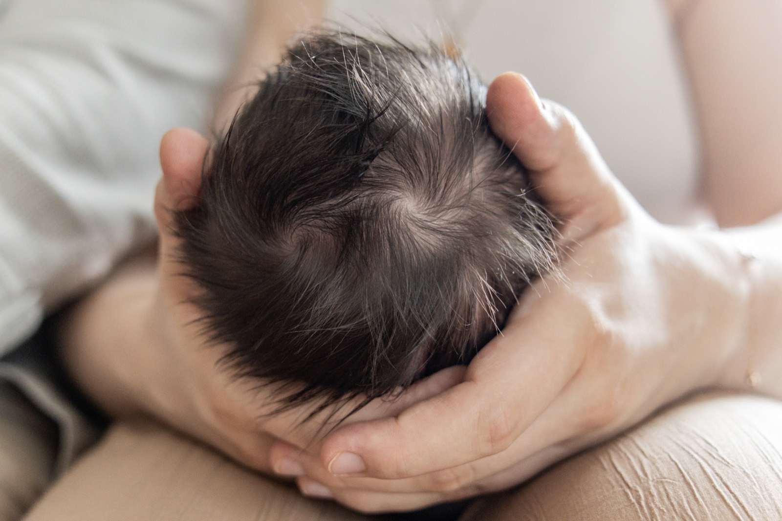 Baby wird liebevoll in den Armen gehalten