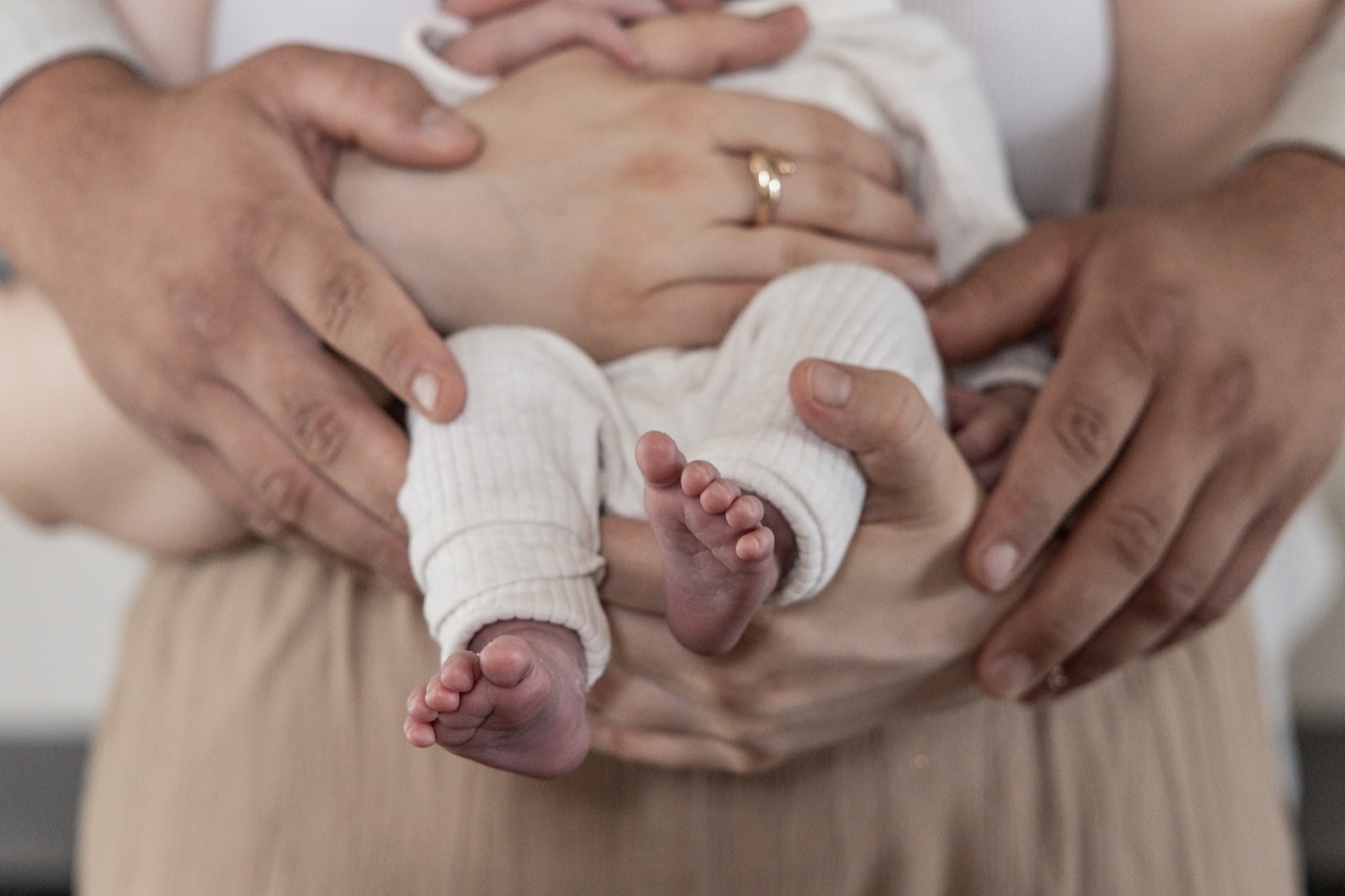 Baby geborgen in den Händen der Eltern